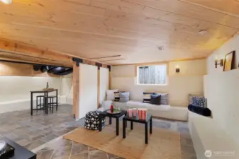 Finished basement area with built in seating, sliding barn door and gorgous tongue and groove ceiling.