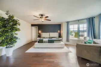 Looking at large primary bedroom from bathroom entry