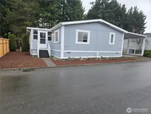 A two-car carport provides covered parking, complemented by a storage shed for tools and seasonal items.