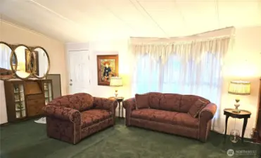 The living room opens directly into an extended 183 sq ft sunroom—an ideal bonus space for relaxing, hobbies, or year-round enjoyment.