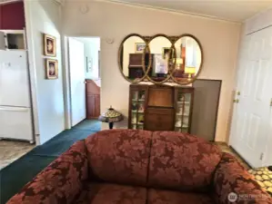 The living room flows toward the private wing of the home, where the primary bedroom and bath are located.