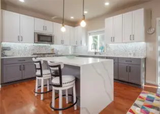 New kitchen featuring a dramatic waterfall island centerpiece.