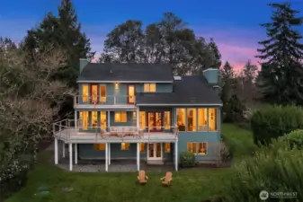 Twilight exterior showcasing warm interior lighting and serene natural surroundings.