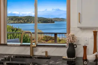Kitchen window framing stunning waterfront views, bringing the outdoors in.