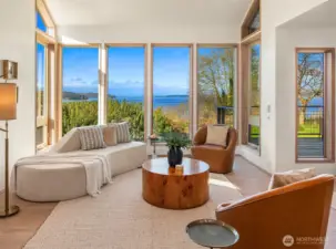 Bright living room with floor-to-ceiling windows and picturesque water views.