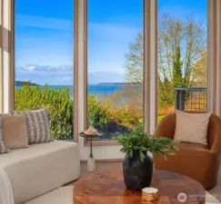 Cozy sitting area with large windows framing picturesque water and territorial views.