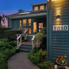 Twilight entry showcasing welcoming front steps, lush landscaping, and charming curb appeal.