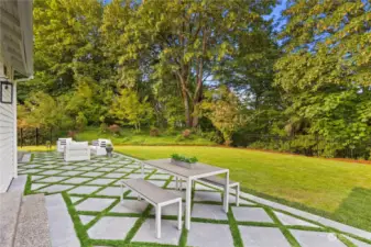 Expansive diamond paver patio with turf for easy maintenance.