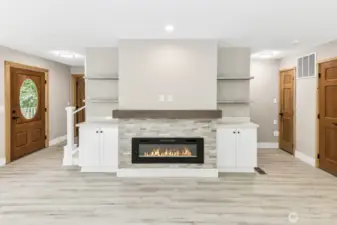 Electric fireplace with some built ins. Front door to the left.