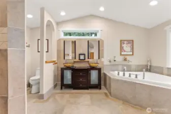 Main Floor Primary Bed En-Suite. Custom tile floors and large soaking tub, plus walk-in shower!