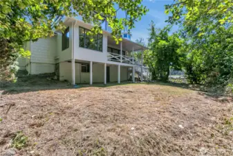 Back of house and partial view of back yard.  Yep! It's been a dry summer. Note lower-area covered patio space across the home's length.