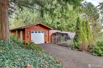 Detached garage with mobile home next to it behind kennel