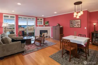 Dining and living rooms with inviting gas fireplace and tall windows facing west that bring in lots of sunshine and amazing views of the sound and Olympics