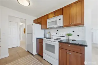 Gorgeous wood cabinetry for warm & style with stunning slab granite countertops & tile backsplash.