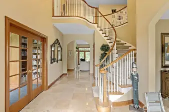 The grand entry. To the left is the library/study. The Italian porcelain tile leads to the living room. French doors open out to the patio, back yard, lakeshore and golf course. The sweeping stairway is a fine example of the exceptional archetectural design of this home.