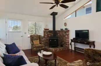 The wood stove provides plenty of heat and is the perfect place to cozy up on chilly evenings. Door to the left leads to the North side of your home.