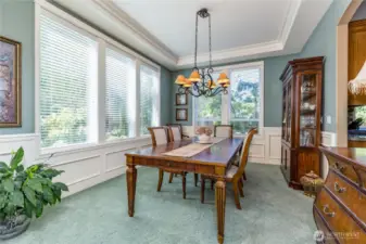 Formal dining room with tray ceiling and large windows offer an elegant yet comfortable space to dine with friends and family