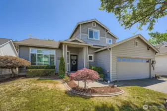 Front of home with mature landscaping and sprinkler system