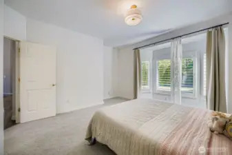 Spacious main floor primary bedroom overlooking backyard