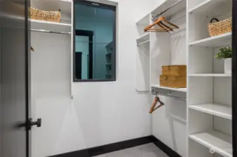 Primary closet with built in cabinets.