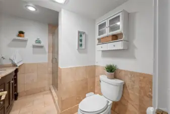 This three-quarter bath sits within the junior suite downstairs and has stone tile throughout.  There are heated floors and a new frameless shower door.  The toilet has a bidet which can be removed if desired.