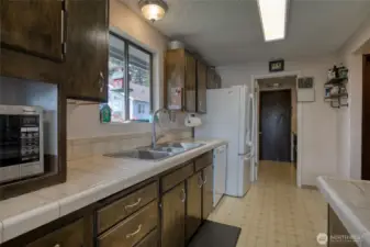 Kitchen, facing utility room that leads to garage.