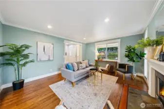 Another view of the living room with oak floors, nice trim and crown molding.