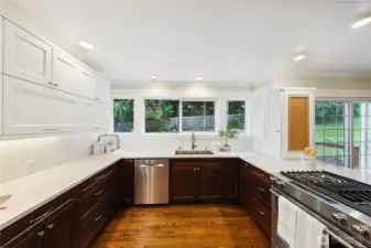 Beautifully updated kitchen with quartz counters, stainless appliances, white upper cabinets, walk-in pantry, utility sink and coffee station.