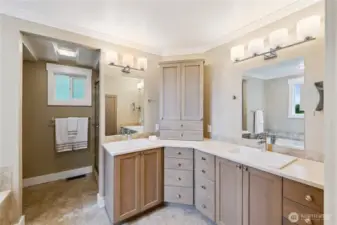Ensuite bathroom with double sink vanity and custom cabinetry, tile walk-in shower and wonderful soaking tub.