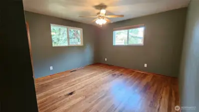 The primary bedroom has hardwood floors, dual closets, a ceiling fan, and two nice-sized windows.