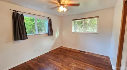 Bedroom number two - with hardwood floors, ceiling fan, closet, and two windows.