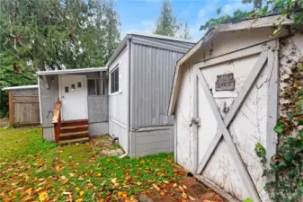 The back entrance and one of three sheds