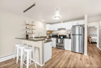 Open kitchen with granite countertops and stainless steel appliances.