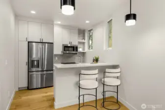 Sleek kitchen workflow showcasing the premium stainless steel appliances and designer pendant lighting