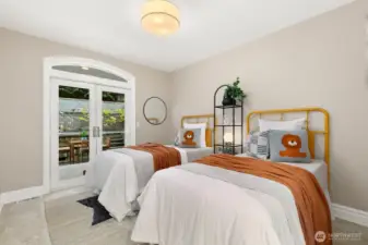 First of three bedrooms on the main level. This one is the smallest of the three and still has two beds! Shared full bath is just across the hall from this room. French doors lead to the back covered patio and backyard.