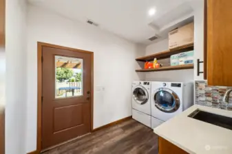 Discover convenience in the well-appointed laundry room, featuring ample space, a utility sink, cabinet storage, and easy access to the rear deck, making household tasks a breeze.