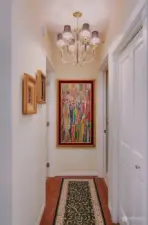 Hallway from the living area to Bedroom and Bath has an added  coat closet and chandelier lighting