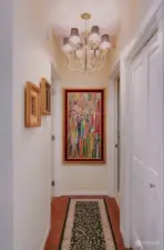 Hallway from the living area to Bedroom and Bath has an added  coat closet and chandelier lighting