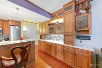 11 Feet of custom cabinetry integrated to extend kitchen & includes Pantry, wine rack, dish cabinets, pull out printer shelf, computer garage, bar area and more!