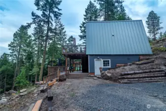 From the driveway to the cabin. white door is the entrance into a nice workshop or storage area