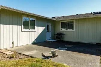 Back patio area .  The door leads to bonus room.  Window on same wall as door is the garage .  Other window looks into second bedroom.