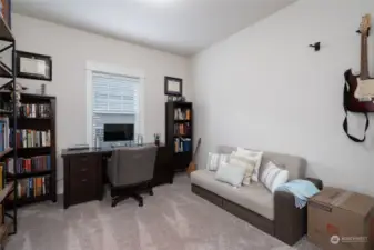 Main floor bedroom off the great room with neutral carpeting. This is one of 4 bedrooms in this home. Bath with shower is located just around the corner from this bedroom.