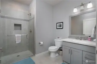 Main floor bathroom with tiled walk in shower, solid surface counters and tile floors.