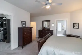 Another view of the primary bedroom showing the door to walk in closet, and entrance to the expansive bath.