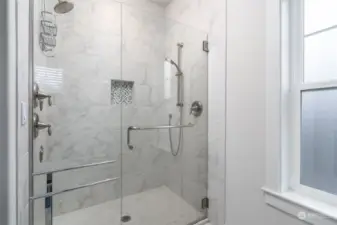 Primary bathroom walk in shower with double shower heads and additional shower jets.