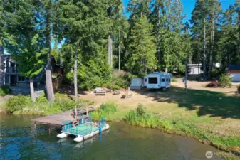 From the lake showing your .34-acre property with 104' of lakefront. Ready for camping with RV and shed with plenty of storage.