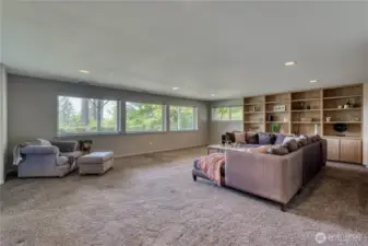 Now let's go downstairs to this giant space with lots of built-ins, windows and a view of the backyard and the water.