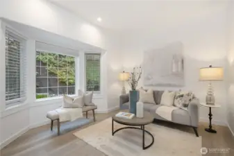 Living room features east facing bay windows, lots of natural morning light.