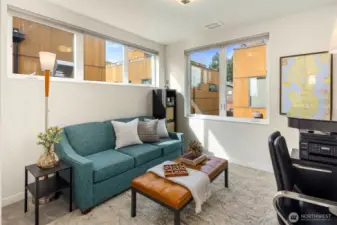 second bedroom, staged as an office with a hide-a bed couch. Corner room with extra windows.