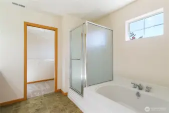 Primary ensuite with soaking tub an door to walk in closet